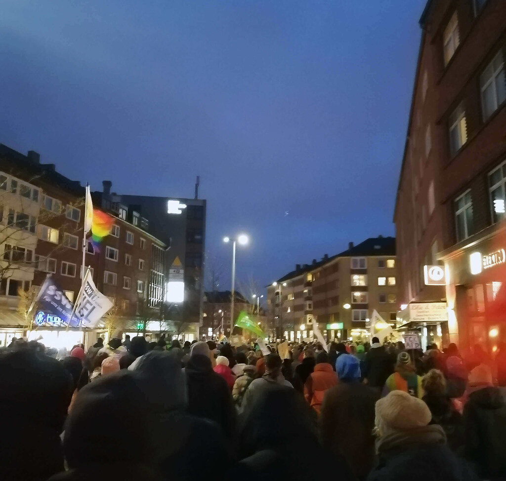 Unzählige Menschen bewegen sich während der Großdemonstration gegen rechts in Kiel am 14. Januar 2024 durch die Holtenauer Straße auf den Dreiecksplatz zu. Dunkelheit hat bereits eingesetzt.