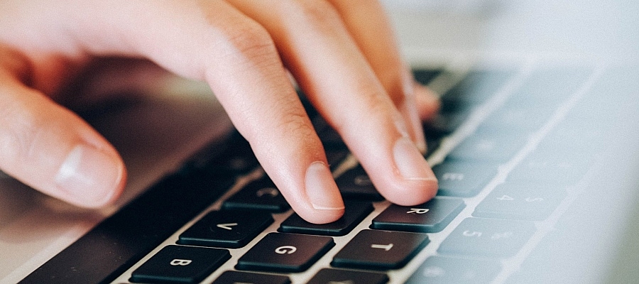 Eine Hand auf einer Tastatur.